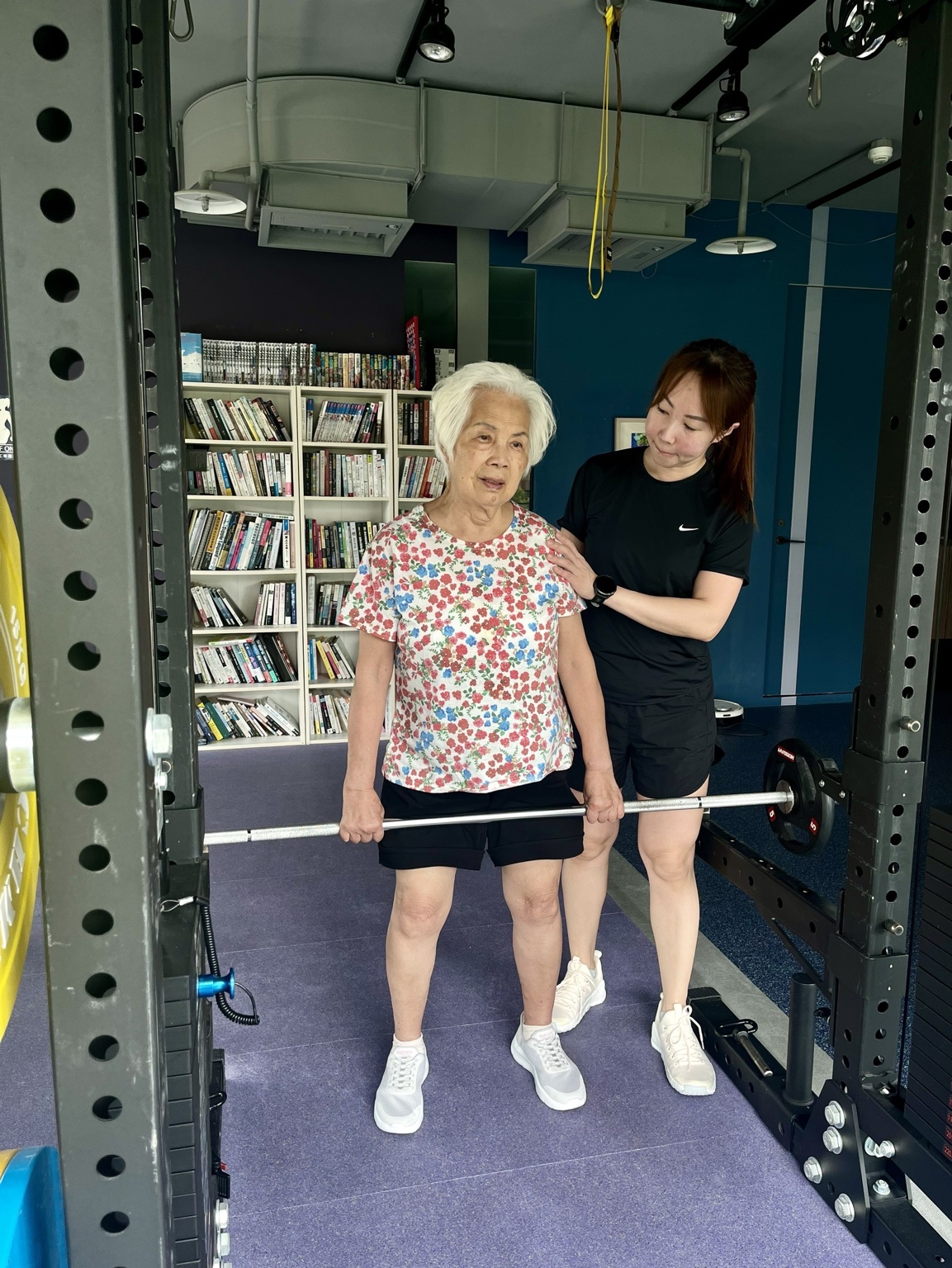 85 歲的 Joanne 周阿嬤在 Claire 教練陪伴下進行持槓肌力訓練